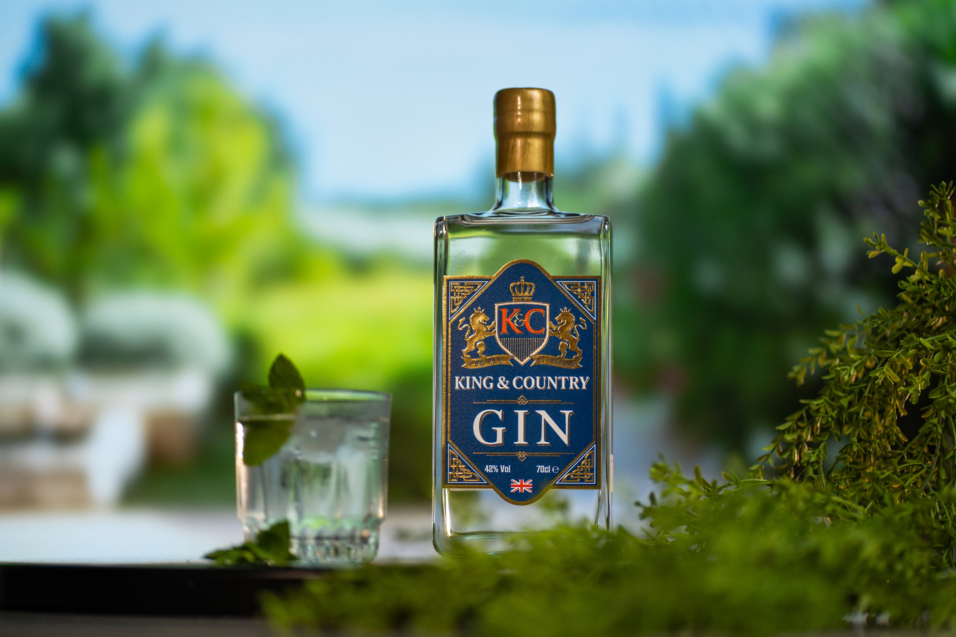 King & Country Gin bottle with a glass of gin and tonic on a blurred natural background